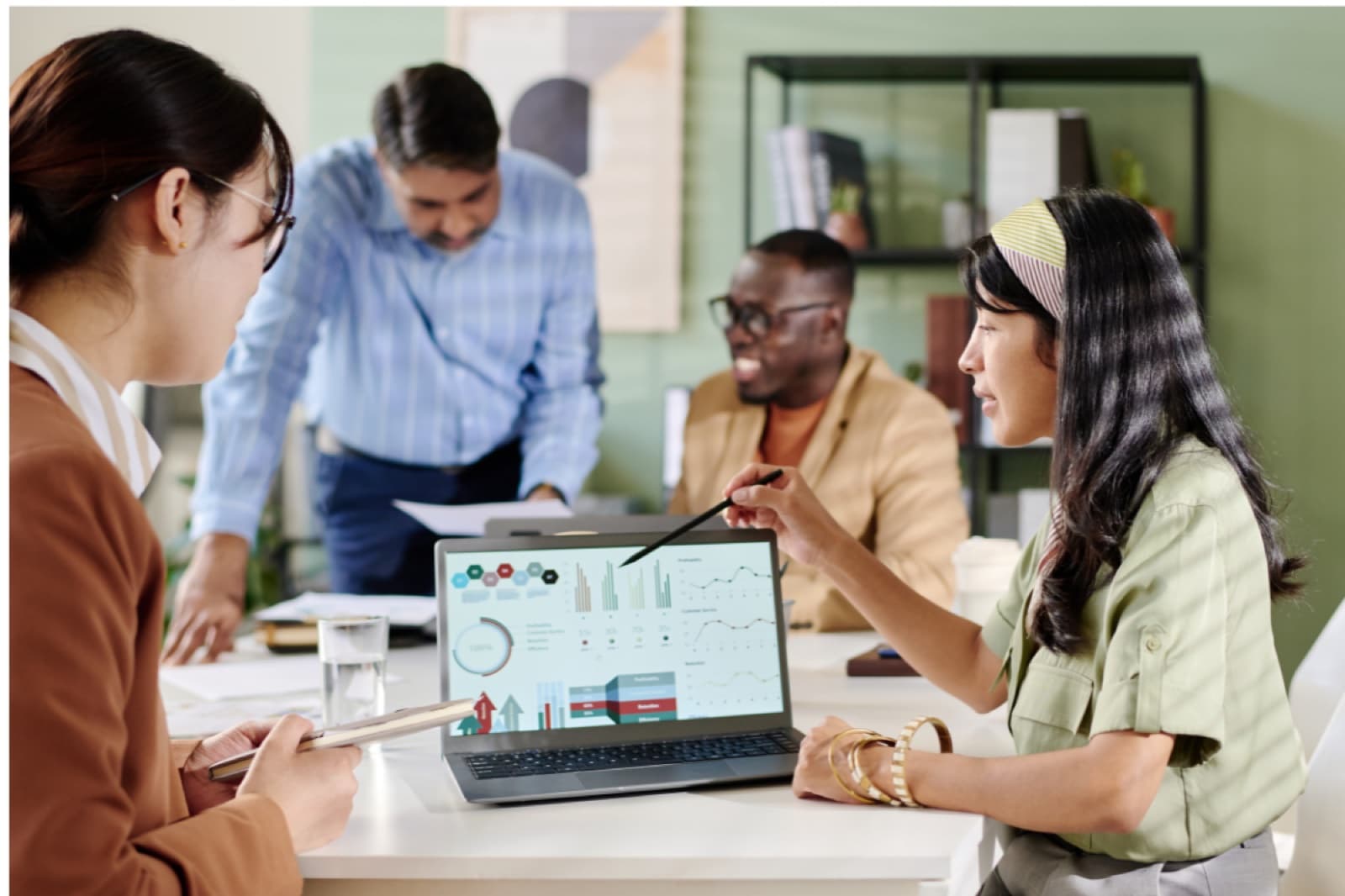 A team reviewing marketing dashboards together on a laptop and monitor.