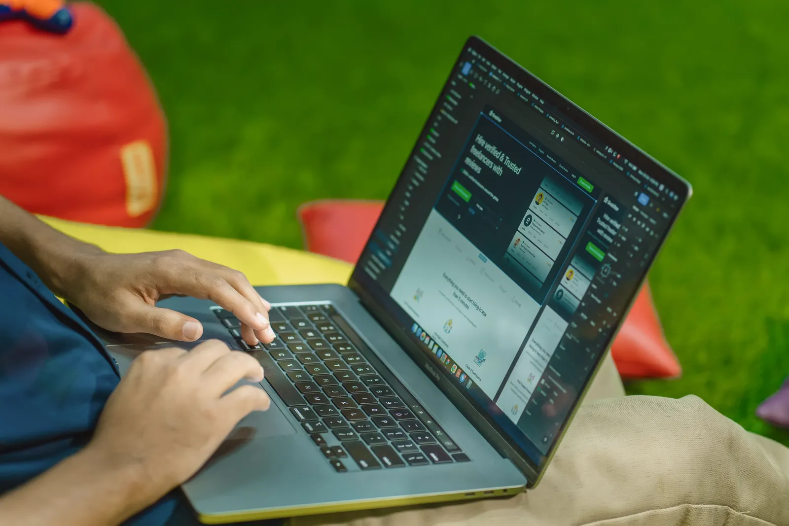Hands on a laptop reviewing a website design in a design tool